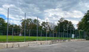 Fertig montierte Ballfanganlage mit hohen Zaunpfosten und Ballfangnetz an einem Sportplatz