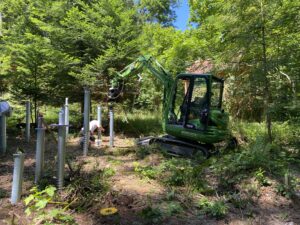 Minibagger der Morlock GmbH bei Fundamentarbeiten im bewaldeten Gelände des Natur-Resorts Tripsdrill